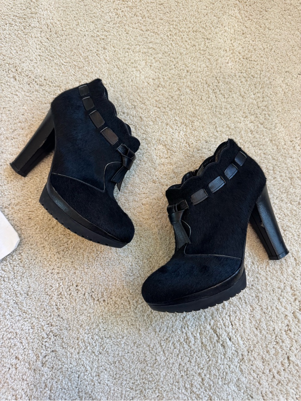 ZORAIDE black calf hair ankle booties with leather strap and tassel accents.